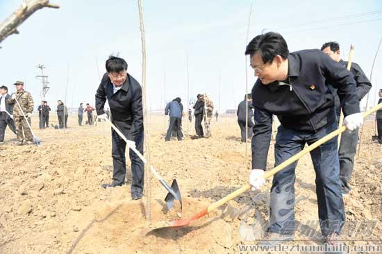 圖為康志民、王春利同黨員志愿者一起參加義務植樹活動。 記者 永翔 攝